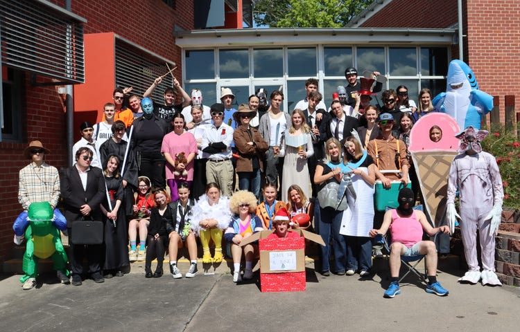 A large group of senior students in fancy dress gathered for a group photo.