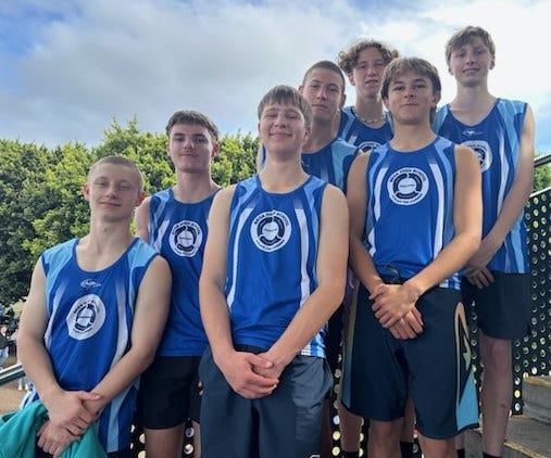 Ïmage of students in sports uniform singlets grouped together ascending up stairs.